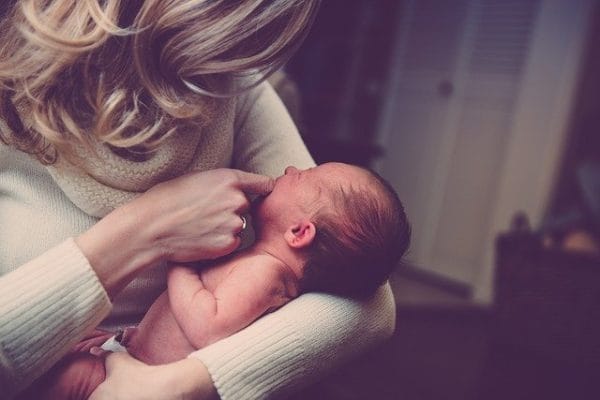 Crisis de lactancia: ¿por qué tu bebé llora al pecho y cuánto dura? Madre con su bebe en grupo postparto con ejercicio fisico y apoyo emocional tras el parto