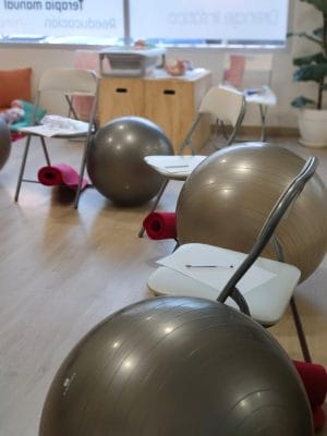Preparación al parto presencial en Valencia Pelotas de pilates y esterillas en la sala del curso de preparación al parto para practicar posturas de parto